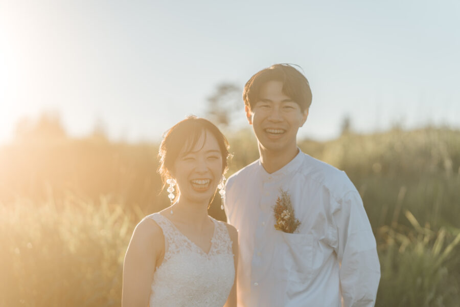 夕日を背にキラキラした笑顔の新郎新婦