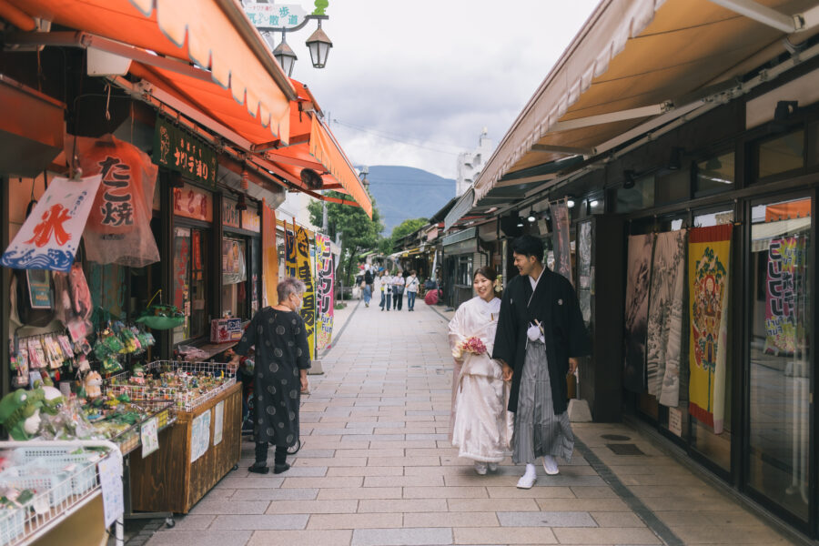 なわて通りを歩く新郎新婦にお祝いの言葉をかける店主