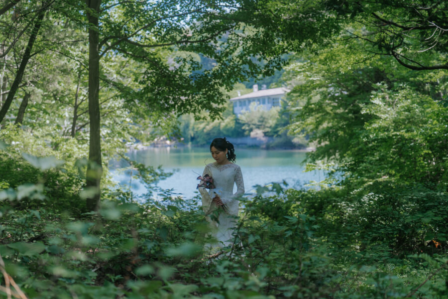森の中にある湖のほとりに佇む花嫁